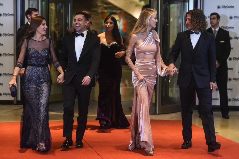 Former Barcelona players Xavi Alonso, Carles Puyol and their wives pose on a red carpet upon arrival to attend Argentine football star Lionel Messi and Antonella Roccuzzo's wedding in Rosario, Santa Fe province, Argentina on June 30, 2017. Footballers and celebrities including pop singer Shakira gathered for the "wedding of the century" in Lionel Messi's Argentine hometown as the Barcelona superstar prepared to marry his childhood sweetheart Antonella Roccuzzo. / AFP PHOTO / EITAN ABRAMOVICH
