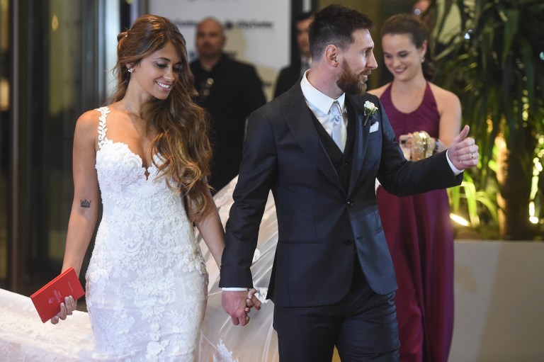 Argentine football star Lionel Messi and bride Antonella Roccuzzo pose for photographers just after their wedding at the City Centre Complex in Rosario, Santa Fe province, Argentina on June 30, 2017. Footballers and celebrities including pop singer Shakira gathered Friday for the "wedding of the century" in Lionel Messi's Argentine hometown as the Barcelona superstar prepared to marry his childhood sweetheart Antonella Roccuzzo. / AFP PHOTO / EITAN ABRAMOVICH