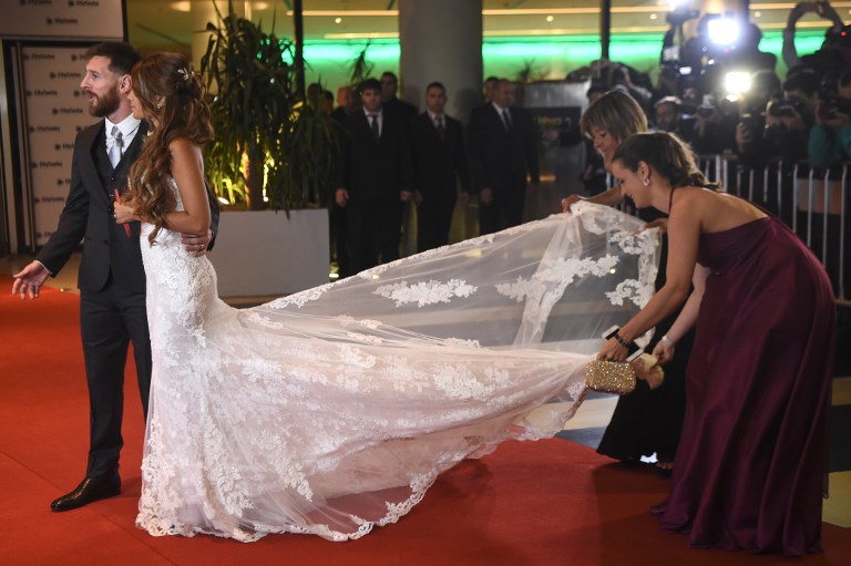 Argentine football star Lionel Messi and bride Antonella Roccuzzo pose for photographers just after their wedding at the City Centre Complex in Rosario, Santa Fe province, Argentina on June 30, 2017. Footballers and celebrities including pop singer Shakira gathered Friday for the "wedding of the century" in Lionel Messi's Argentine hometown as the Barcelona superstar prepared to marry his childhood sweetheart Antonella Roccuzzo. / AFP PHOTO / EITAN ABRAMOVICH